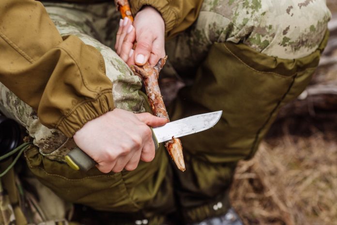 Close-up,Hand,Hunter,Man,With,Knife,Cut,A,Wooden,Stick