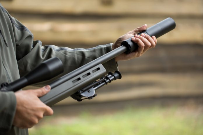 Military,Holds,A,Pistol,With,A,Silencer. Silenziatore